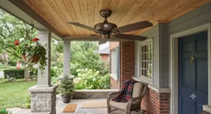 A damp-rated best outdoor ceiling fan hanging from a wooden front porch ceiling, suitable for variable Canadian weather.