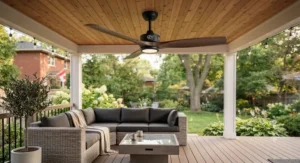 A smart-enabled best outdoor ceiling fan installed over outdoor patio furniture on a backyard deck.