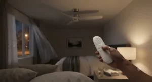 Using a convenient remote control to adjust a quiet ceiling fan for a bedroom during a warm summer night.